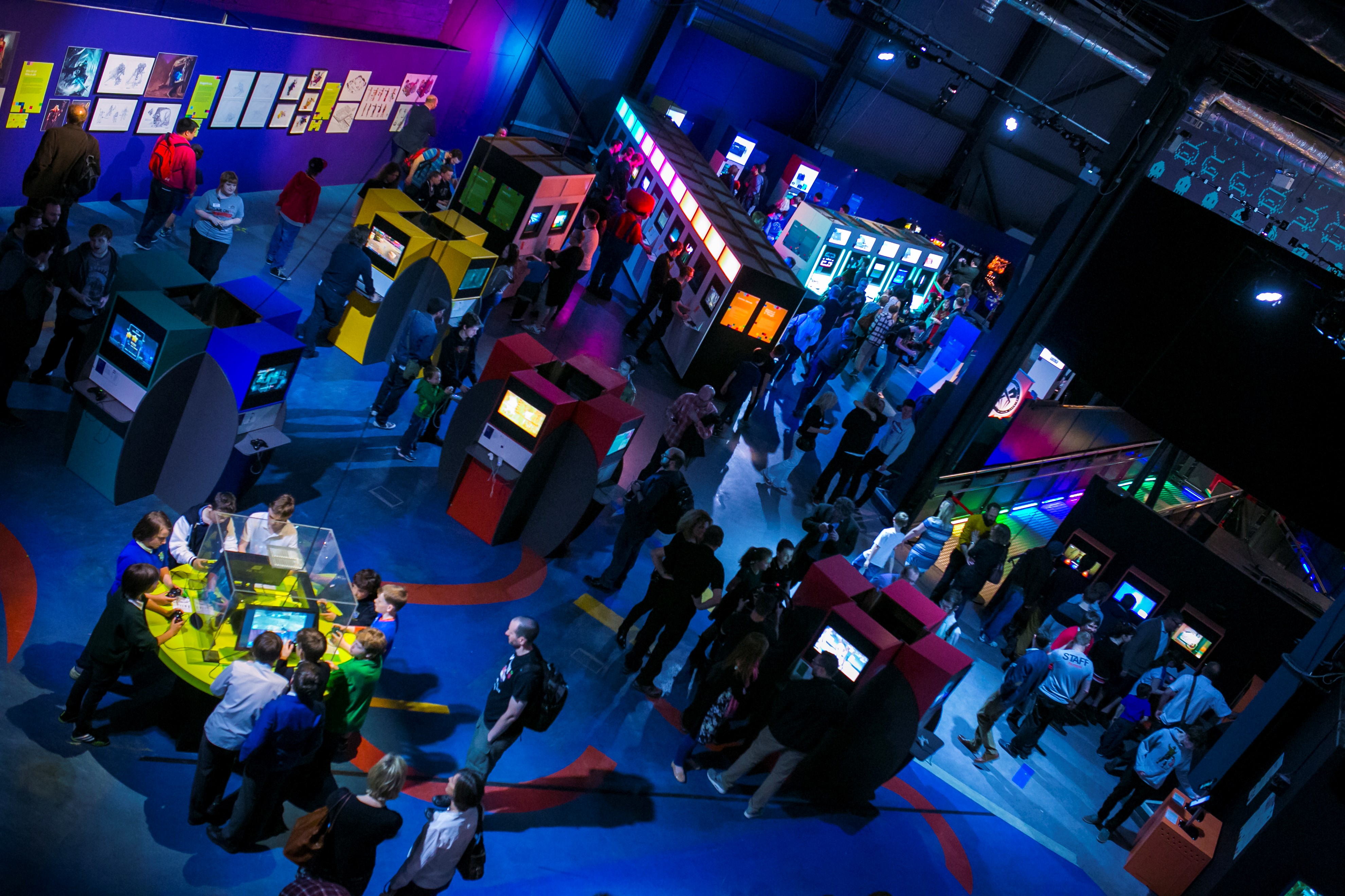 Visitors play with games and consoles across Game On within the exhibition space at Life in Newcastle.