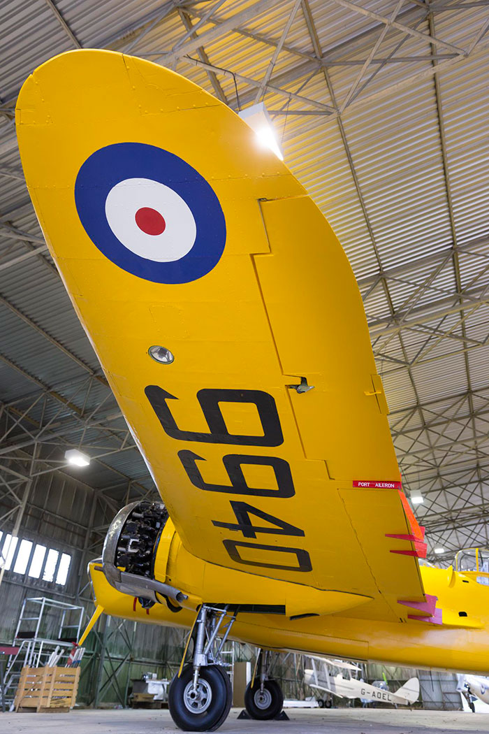 The underside of the wing of a yellow Bristol Bolingbroke aircraft. There is a painted RAF symbol and the numbers 9940.