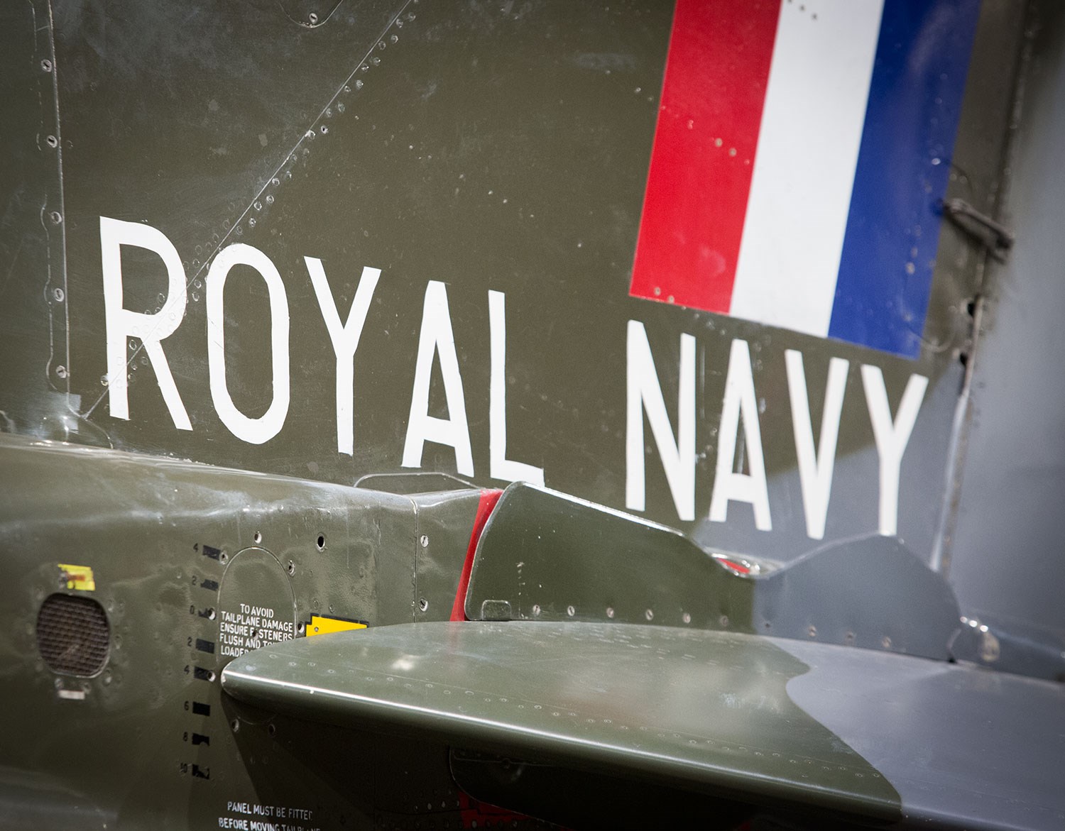 Royal Navy insignia on the side of a green Hawker Siddeley Harrier aircraft.