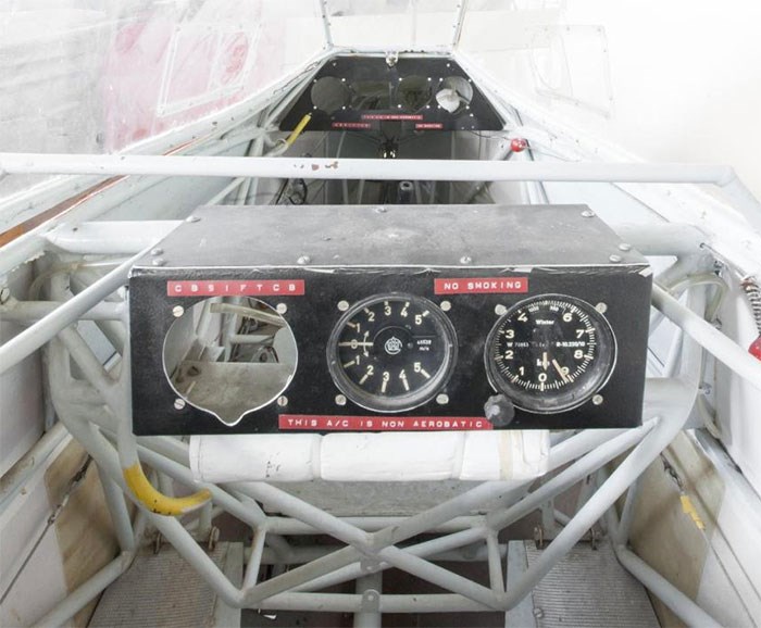 Inside one of two cockpits of the Rhonlerche glider. The framework of the cockpit is white and the dashboards are black. Some dials are missing from the dashboards.