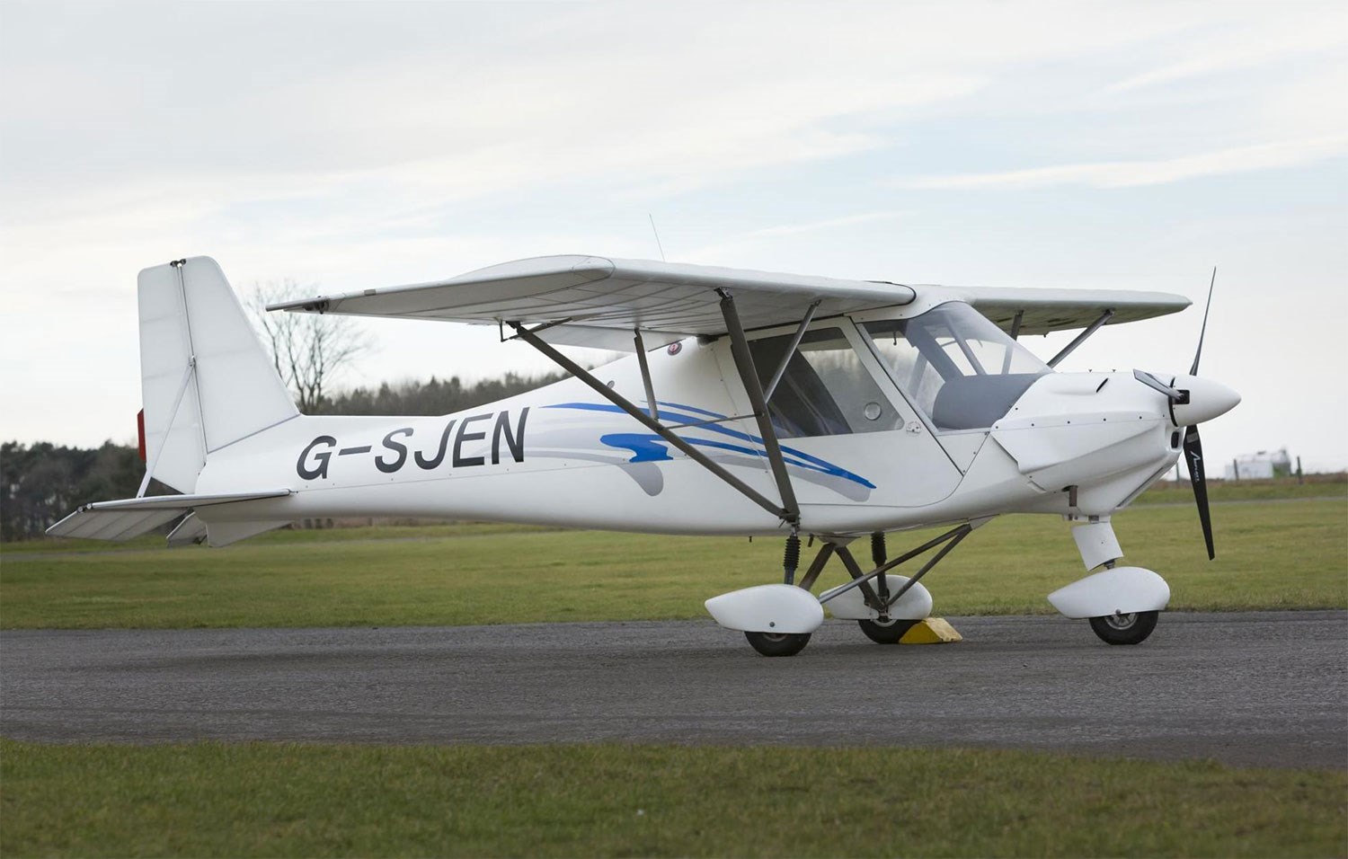 A white Ikarus C42 aircraft on a runway