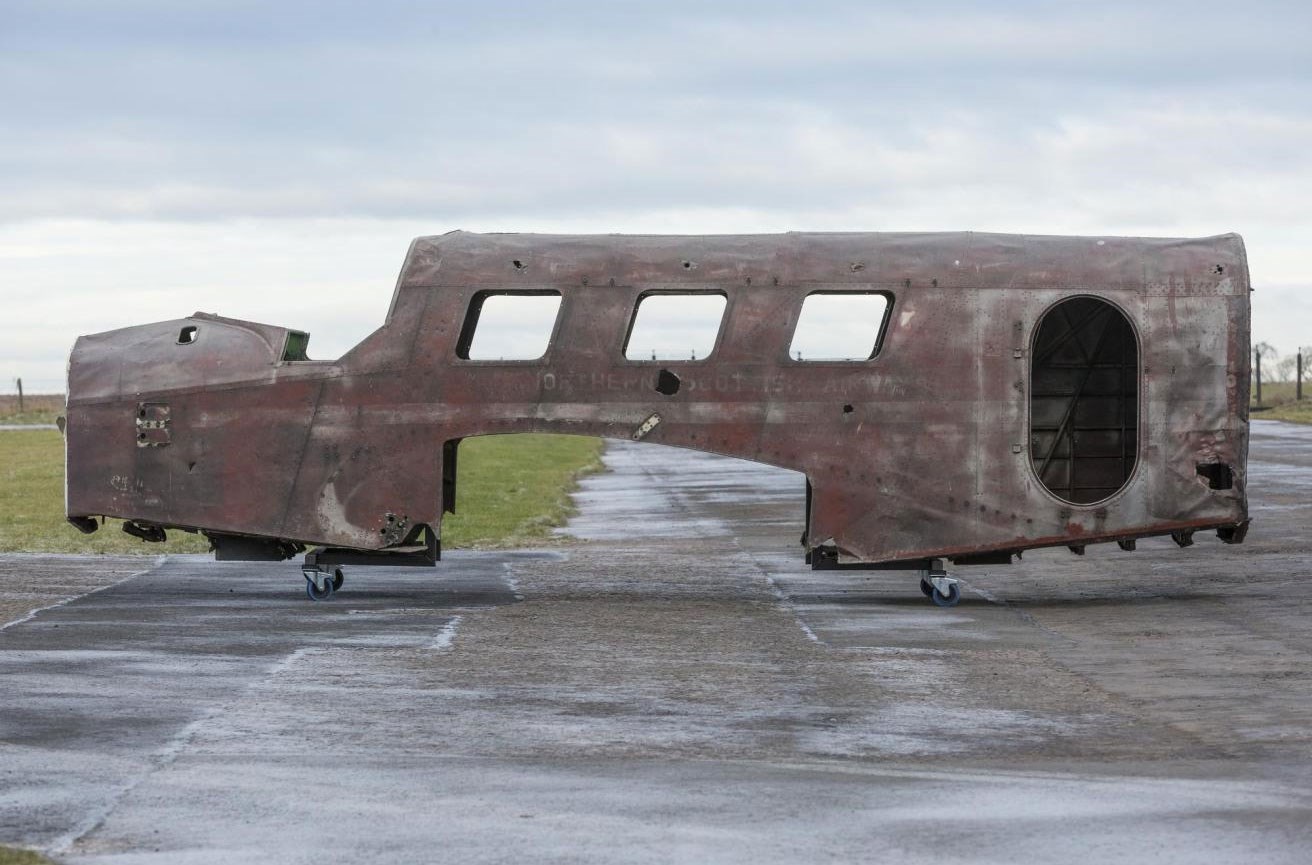 The sideview of the forward fuselage of a Spartan Cruiser aircraft parked on a runway.