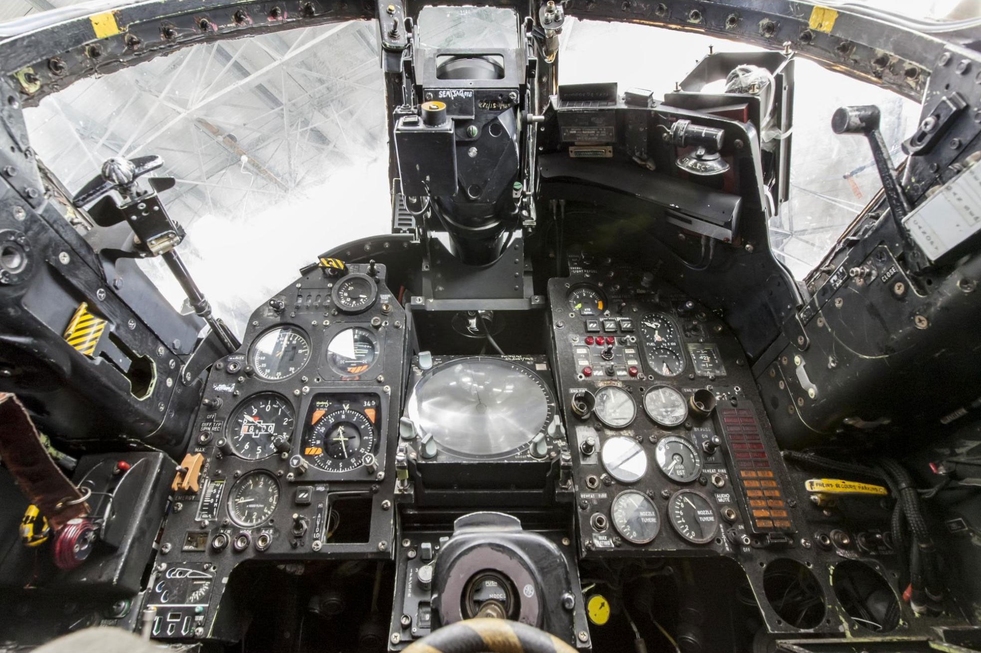 Inside the cockpit of a Jaguar aircraft. There are several dials and switches on the dashboard.