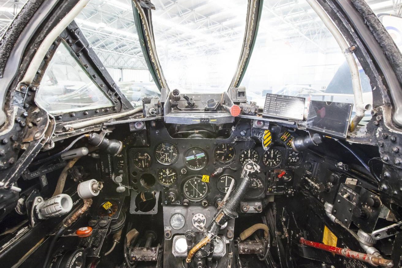 Inside the cockpit of a Meteor aircraft. There are several dials and switches on the dashboard.