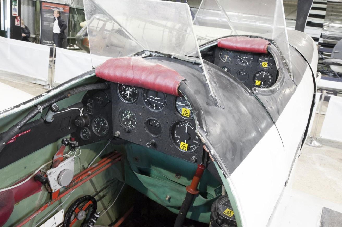 Two cockpits of a Miles M.180 aircraft. There are several dials on the dashboards.