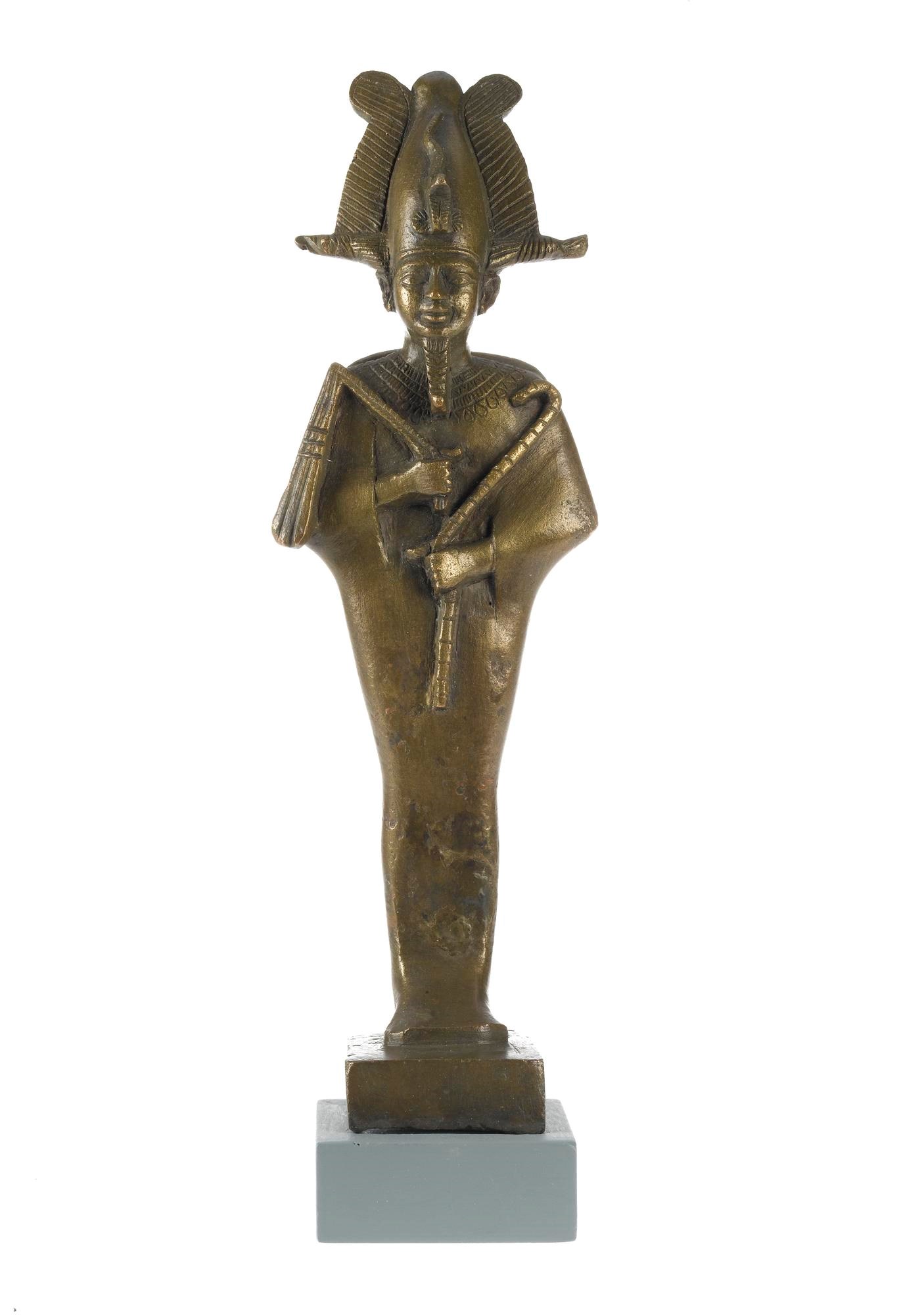 Statuette in bronze of Osiris, standing mummiform with Atef-crown and sceptres, and with seperate wooden base: Ancient Egyptian, from Saqqara, Lower Egypt, Late Dynastic Period, 664-332 BC.