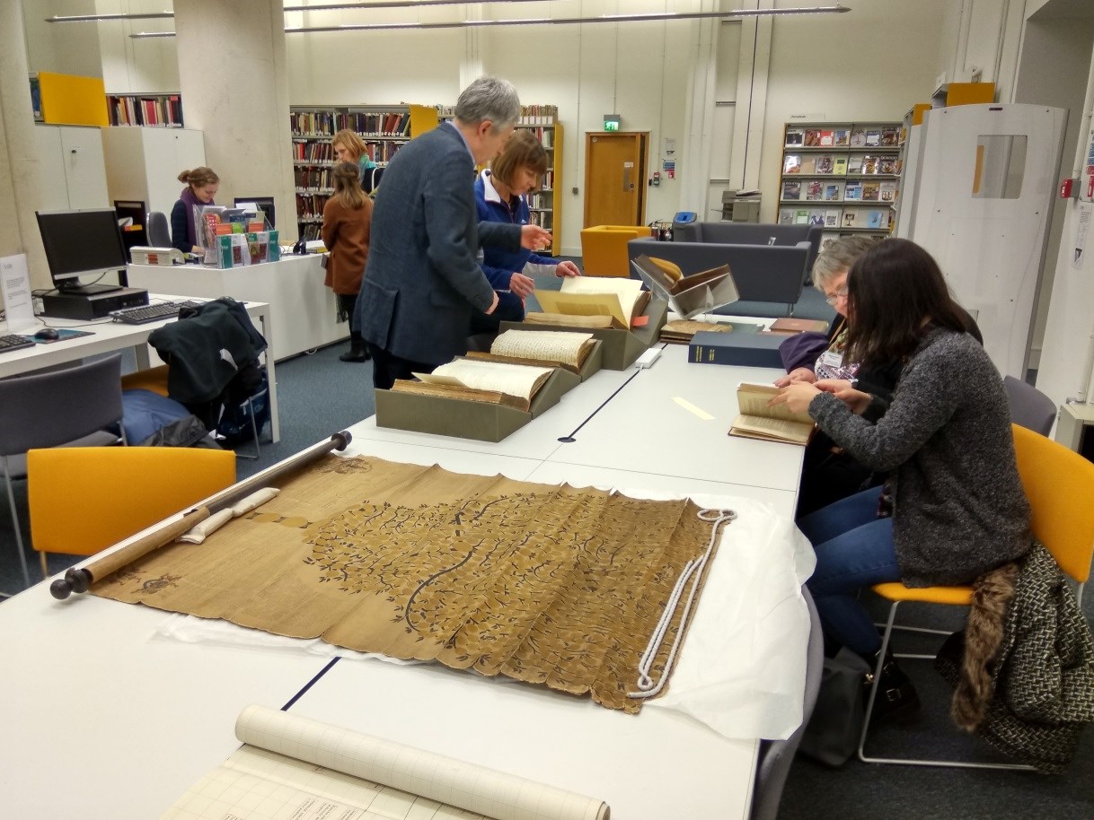 Participants of a workshop looking at books on a table in the library