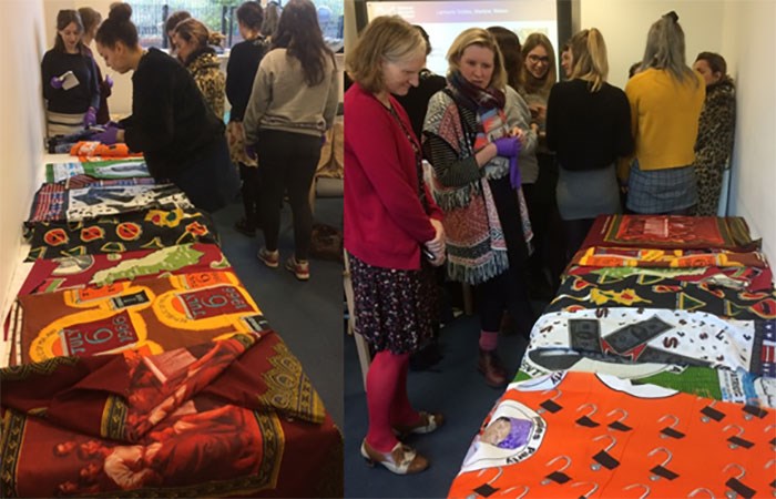 ECA students studying the African cloths laid out on tables.