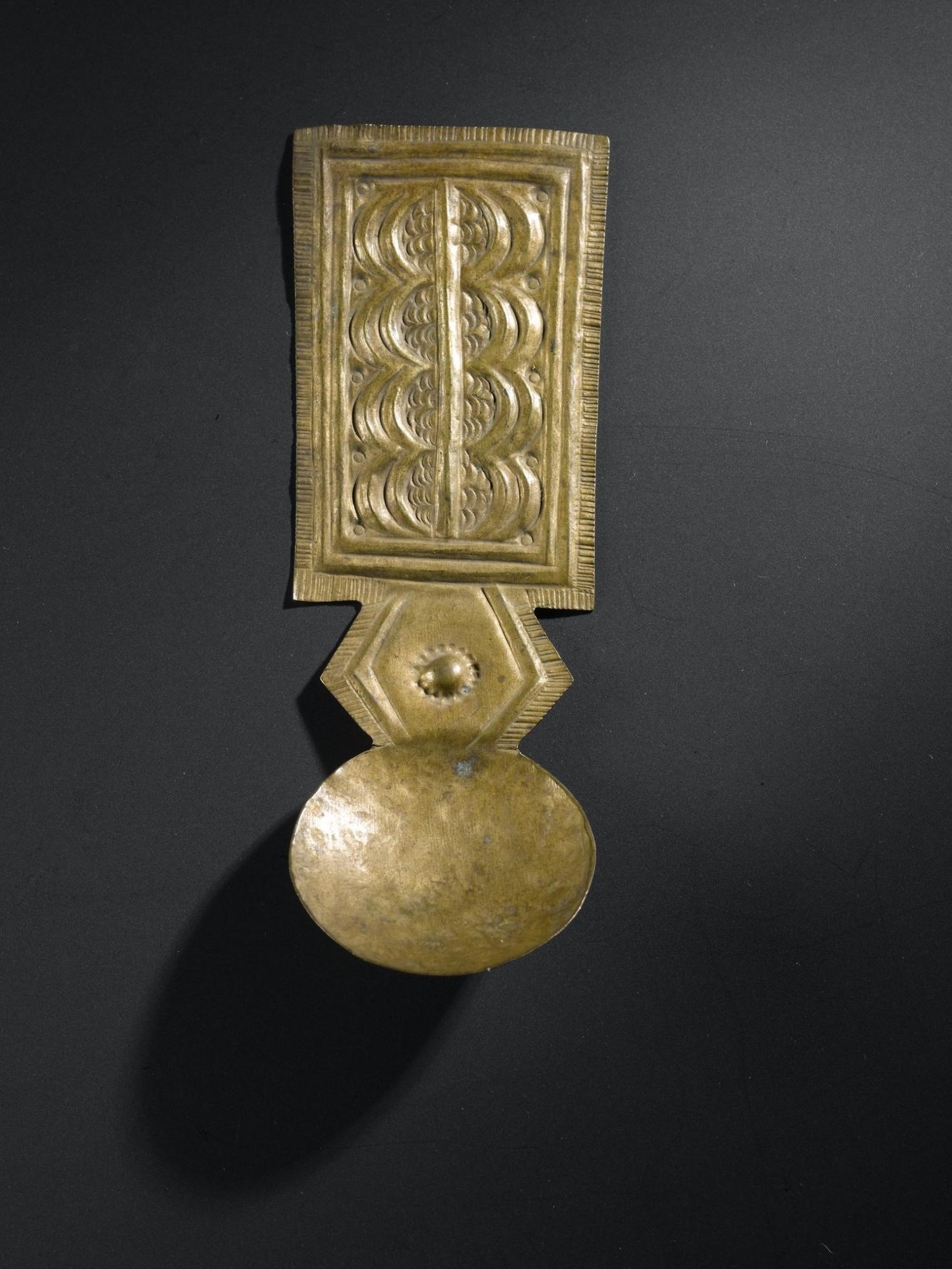 Spoon of beaten brass sheet with shallow circular bowl and flat rectangular handle ornamented with repoussé work: West Africa, Ghana, Asante, late 19th to early 20th century