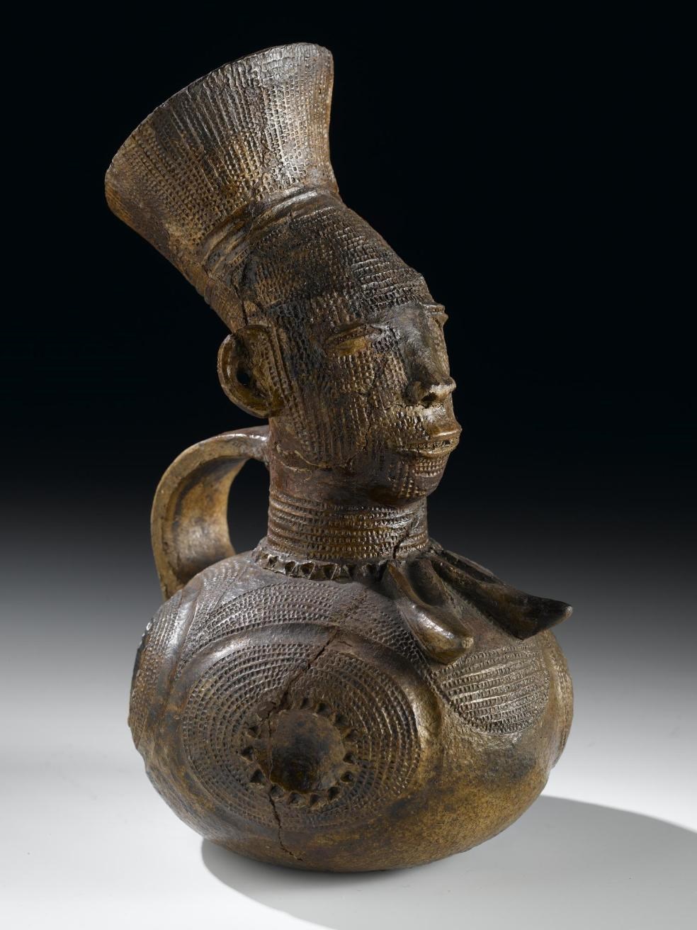 Early 20th century hand-modelled clay jug  from the Democratic Republic of the Congo, in the form of a high status Mangbetu woman with elaborate hairstyle and body decoration.