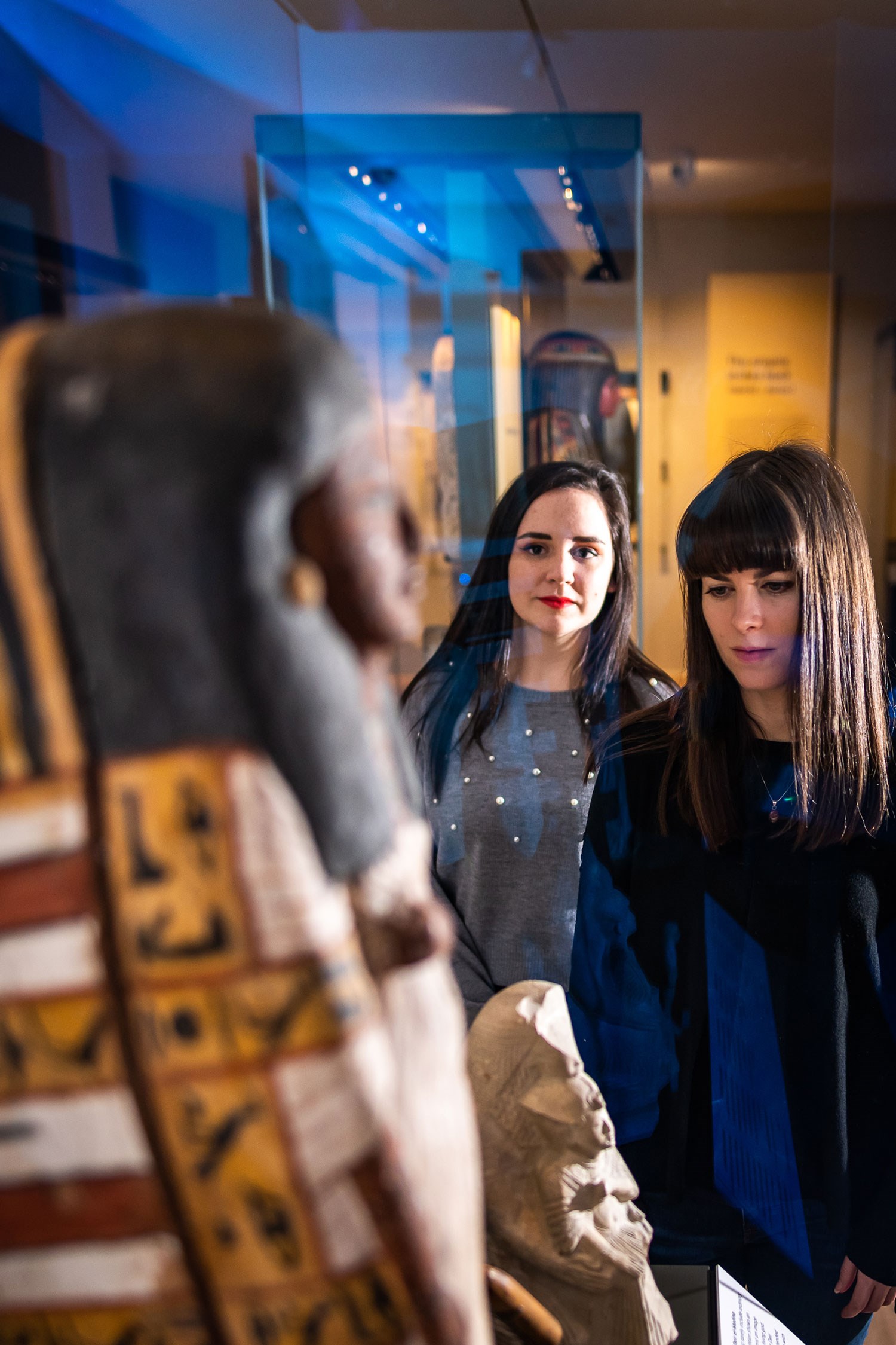 Two visitors examine a sarcophagus in the Ancient Egypt gallery. 