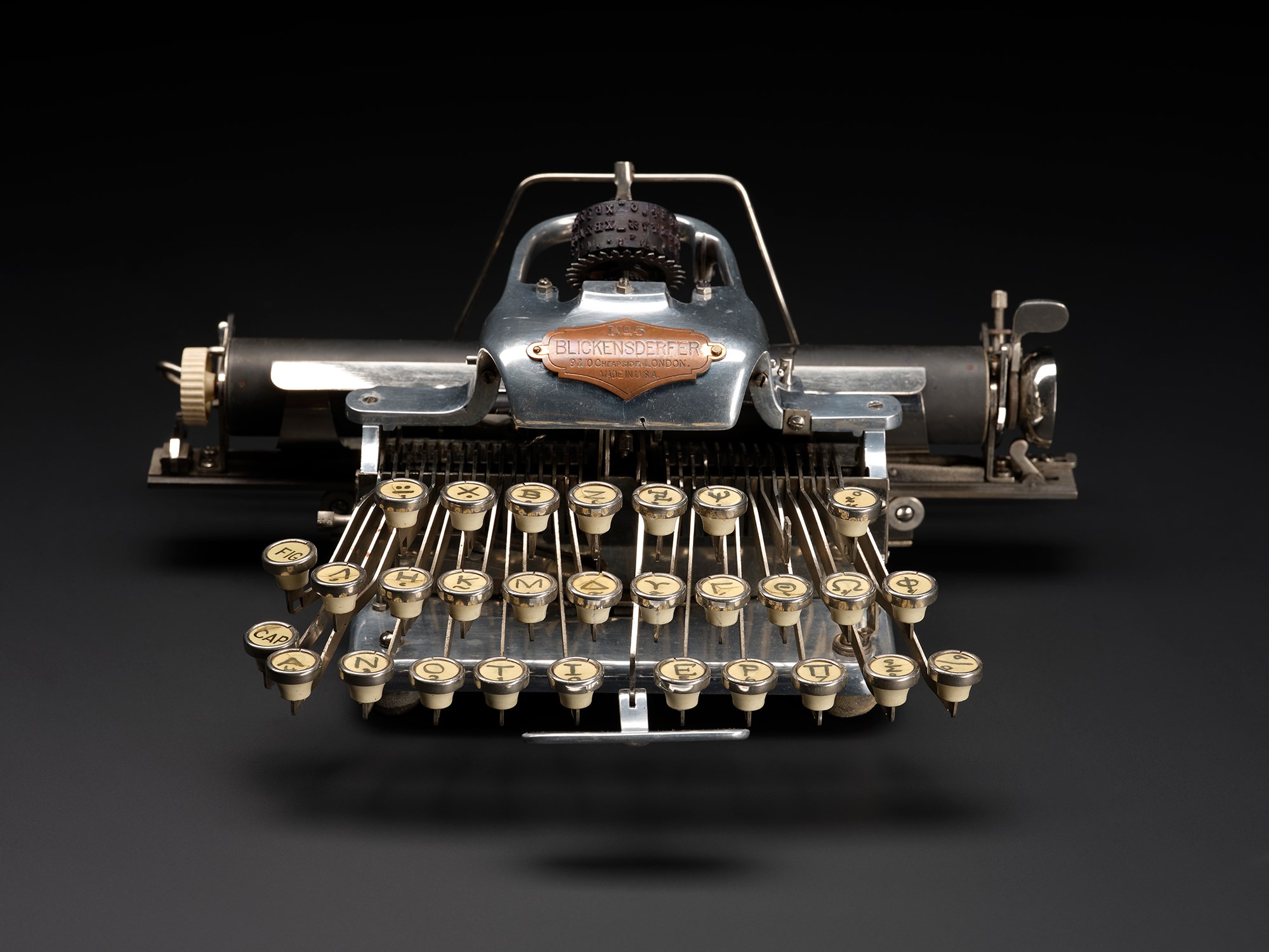 A sleek black typewriter with cream-coloured keys against a dark grey background.