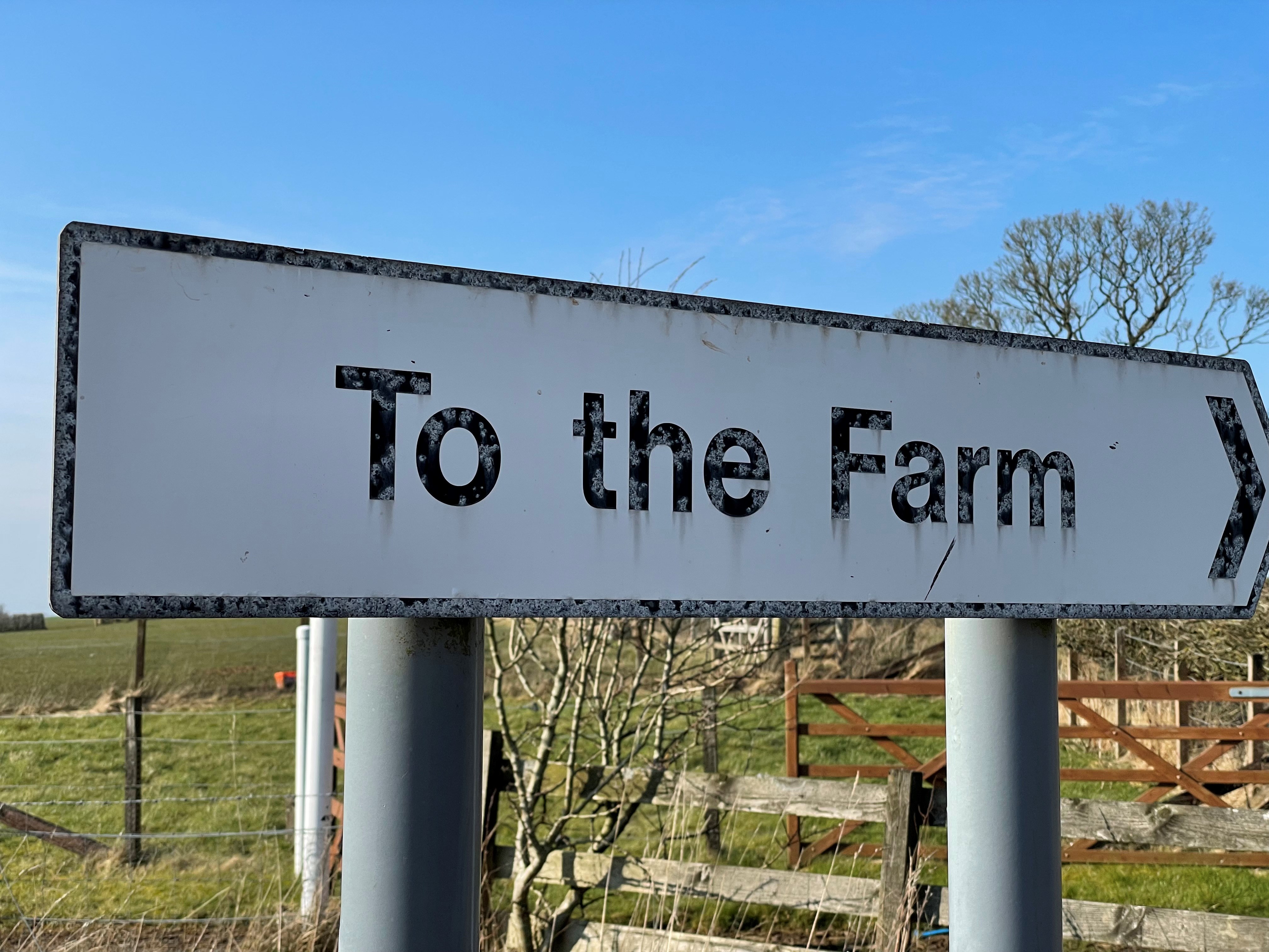 Direction sign that reads "To the farm". 