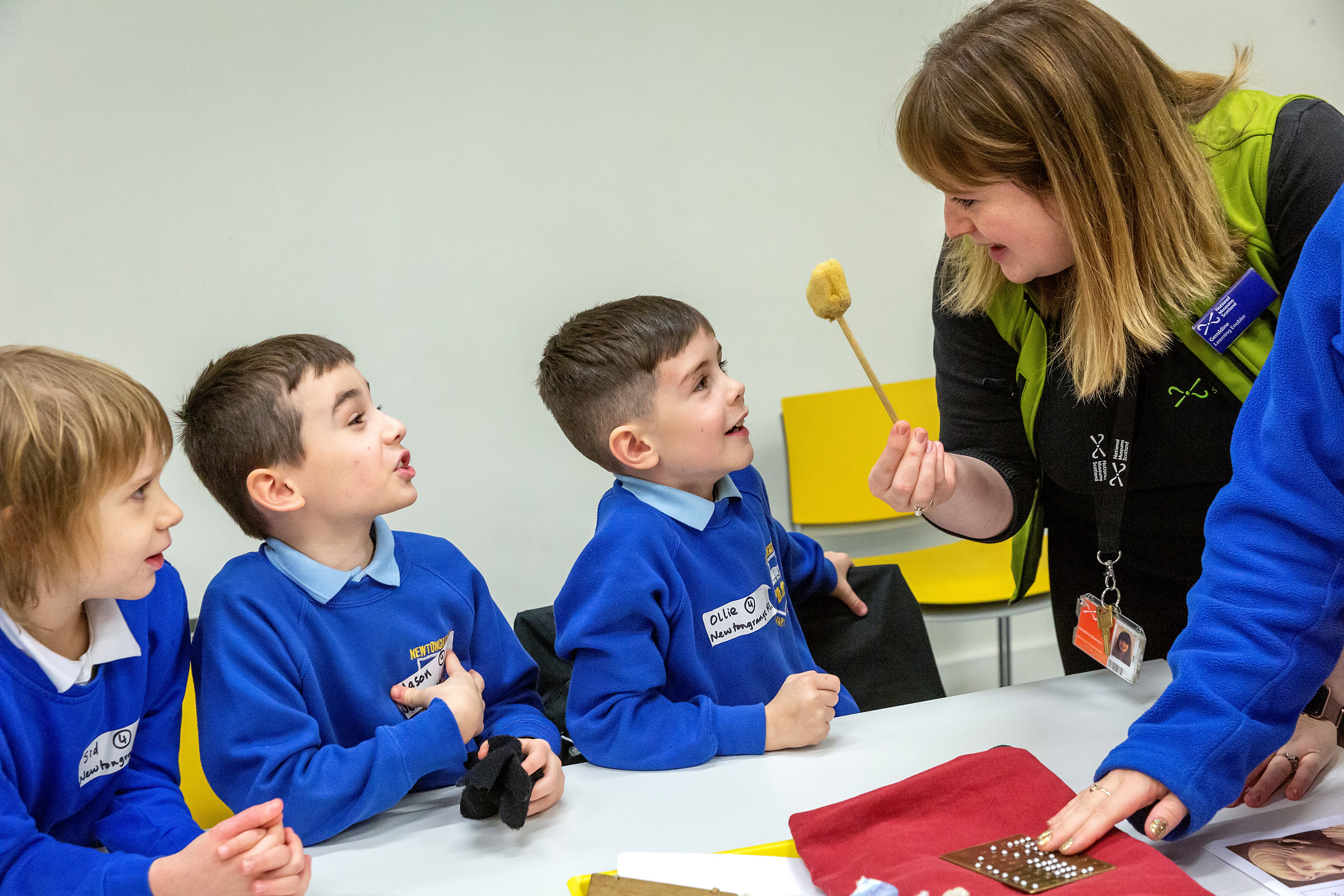 A learning enabler shows a group of primary pupils a sponge on a stick. 