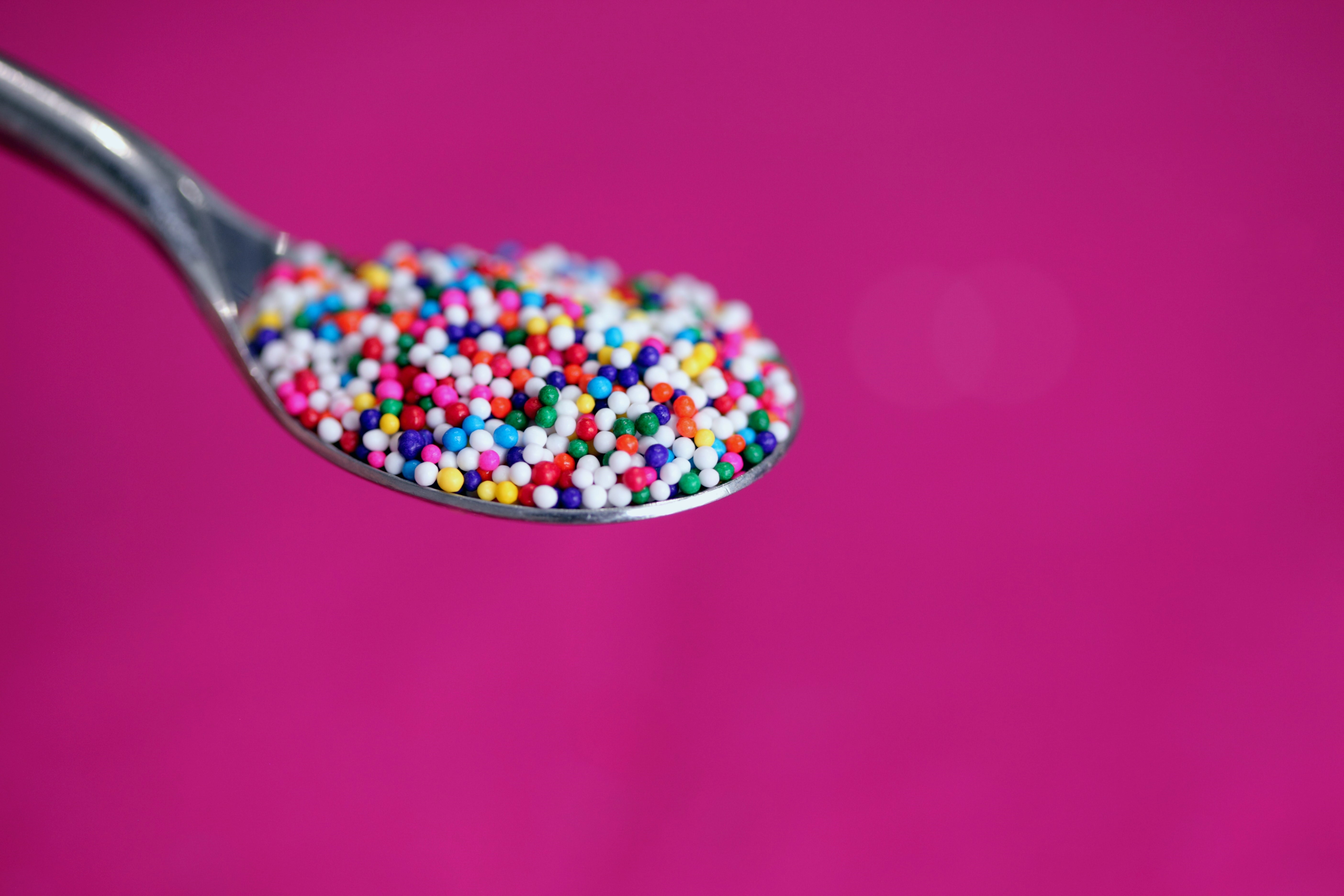 A spoonful of coloured sugar. Photo by Alexander Grey on Unsplash