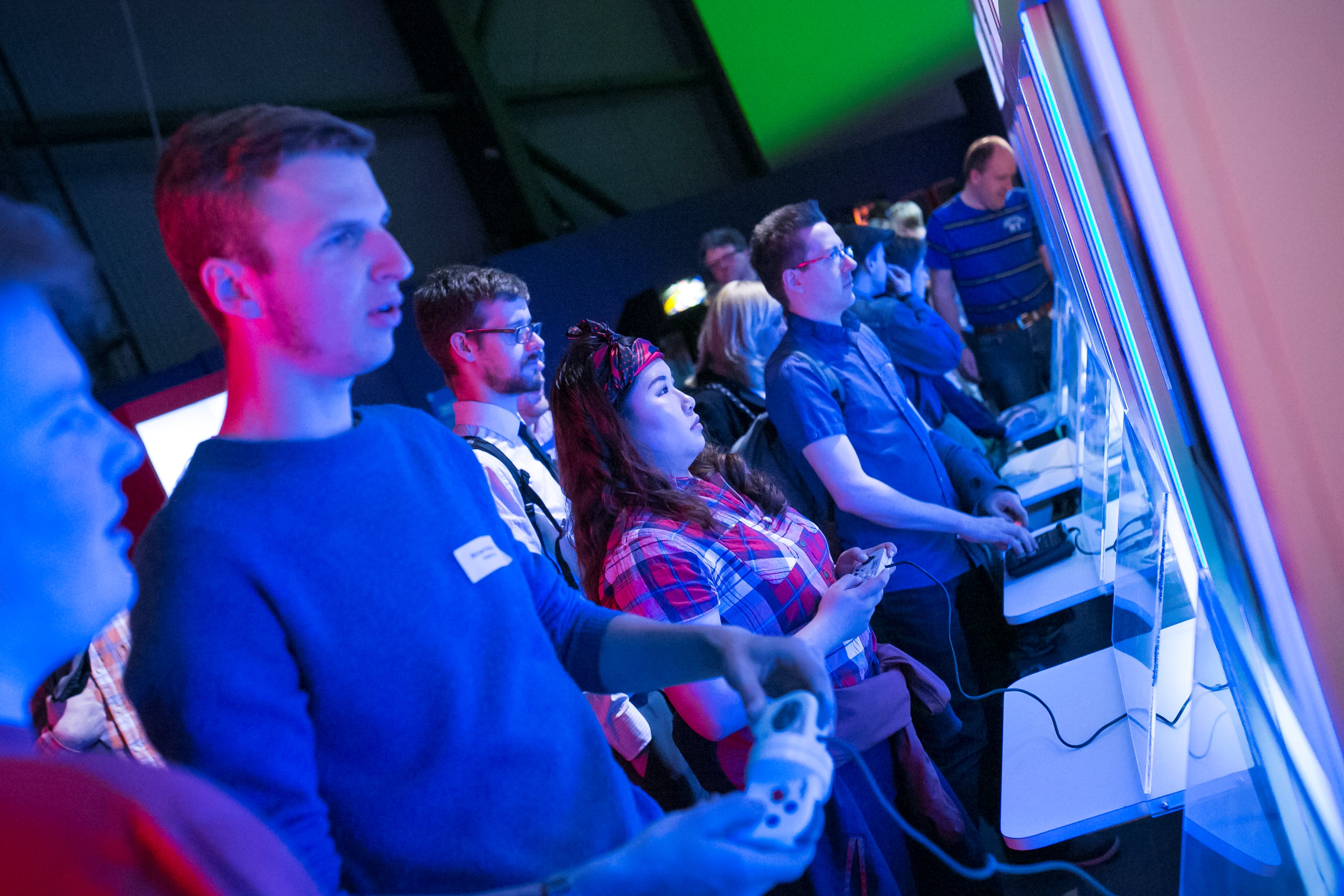 Nine players line up to play across a number of static consoles in a Game On exhibition space at Life in Newcastle.