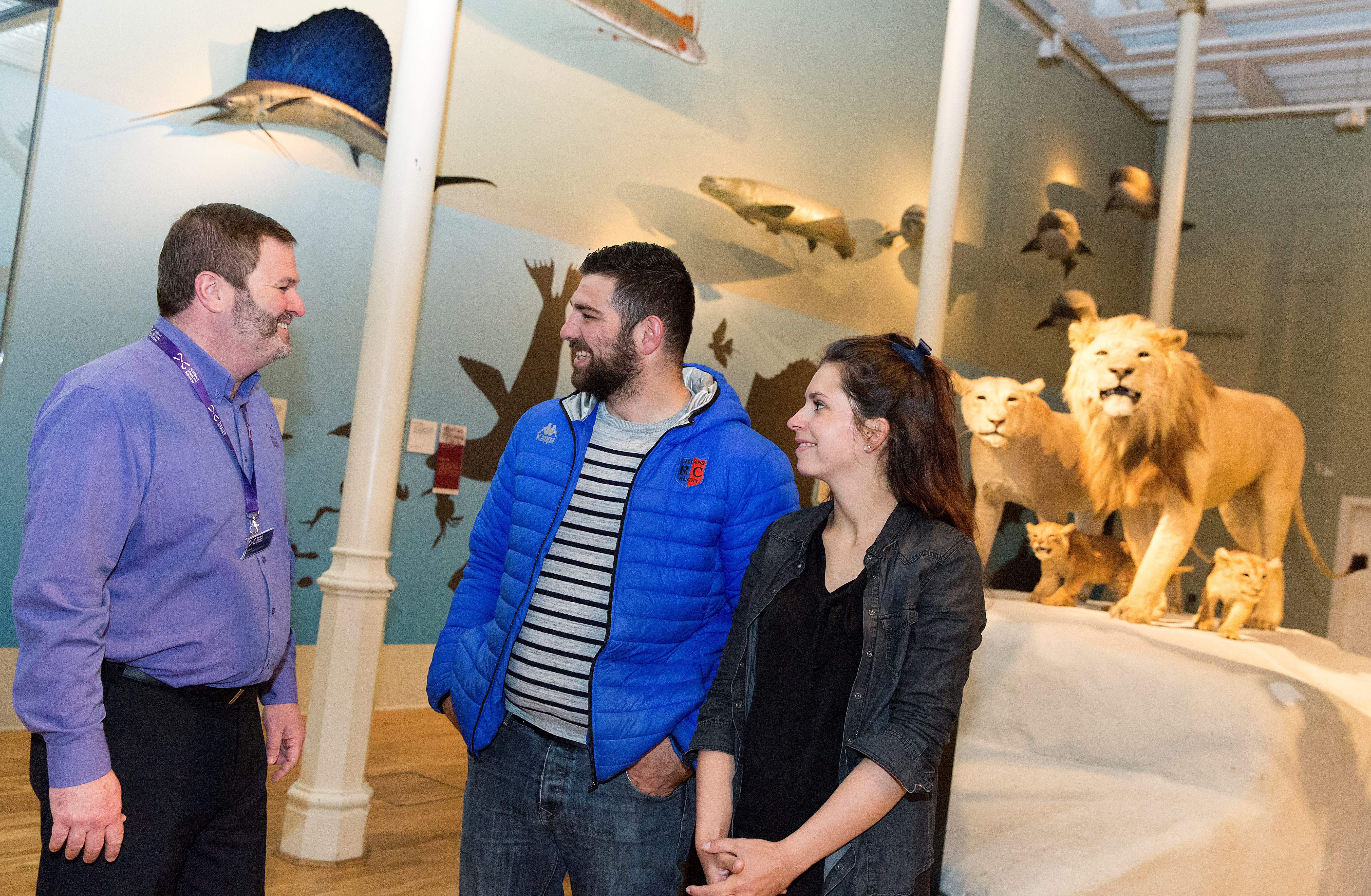 A member of our visitor services team chats with two visitors in the Animal World gallery.