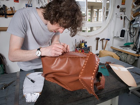Ian Dunlop stitching the leather bag by hand