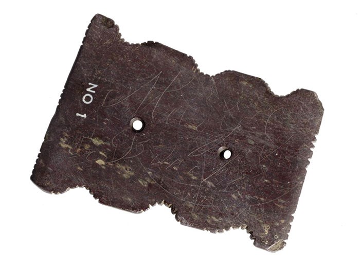 Flat oblong stone, notched on the sides and pierced with two holes, used as a charm for curing disease in Islay. 