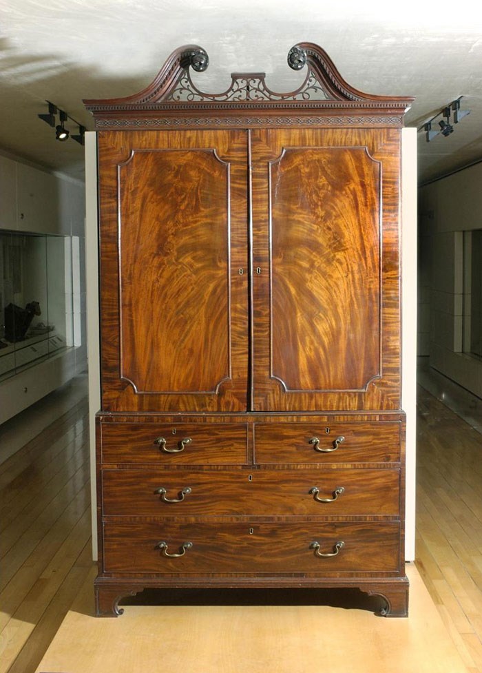 Large upright cabinet with brushstroke-like patterns in the wood, with three lower shelves and one large double-doored compartment.