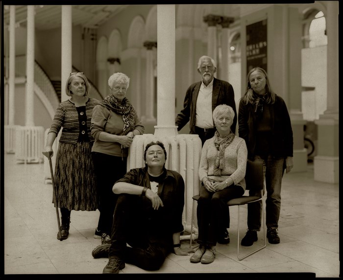 Black and white photo of victorian photo workshop participants sitting around a column