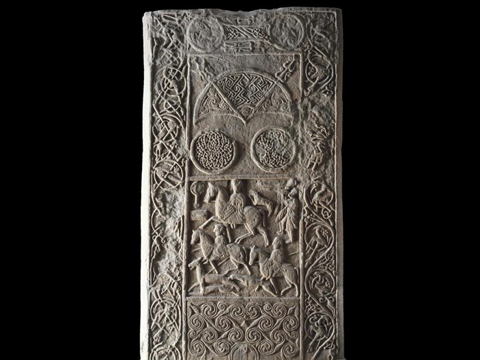 Stone cross slab, the back is highly decorated including a hunting scene, but the original carvings on the front were carved off for re-use as a gravestone, Pictish, found at Hilton of Cadboll, Ross and Cromarty, 7th or 8th century AD