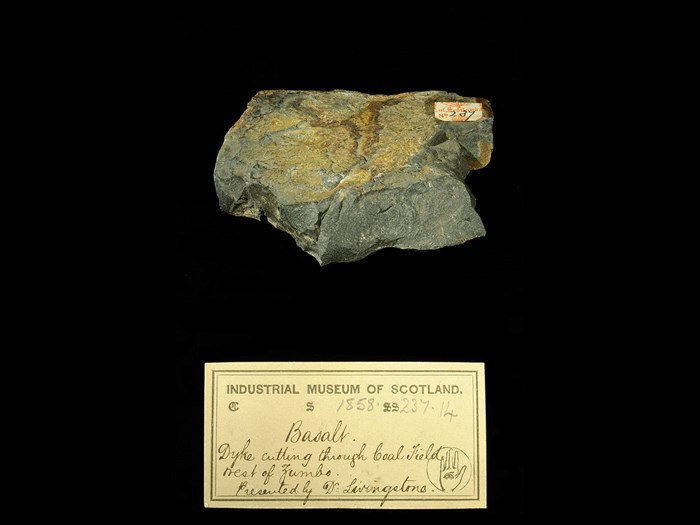 Specimen of basalt with 19th century museum label: ‘Basalt. Dyke cutting through coal field west of Zumbo. Presented by Dr Livingstone.’