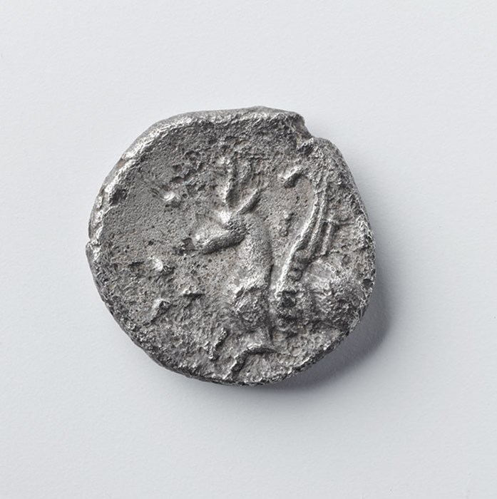 Silver coin showing winged horse with a horned cap