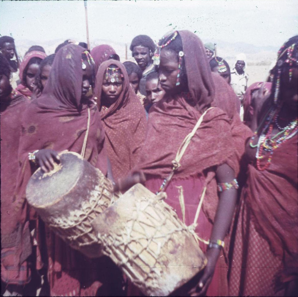 Slide of girls wearing red clothes, playing drums: Eritrea, 1960s, photographed by Jean Jenkins.