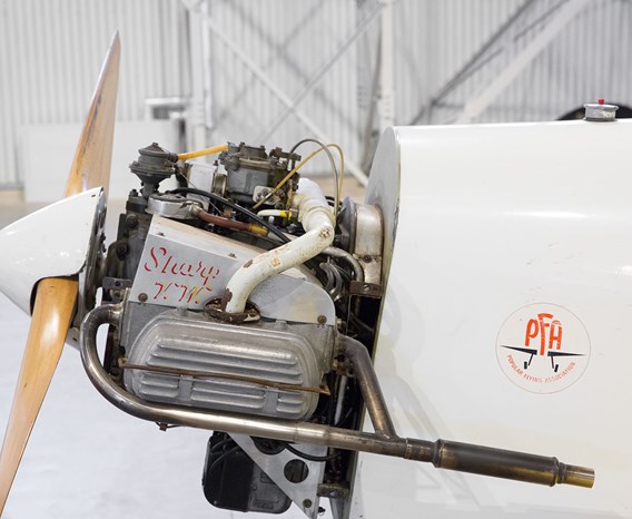 Close-up of the exposed engine and front propeller of a plane.