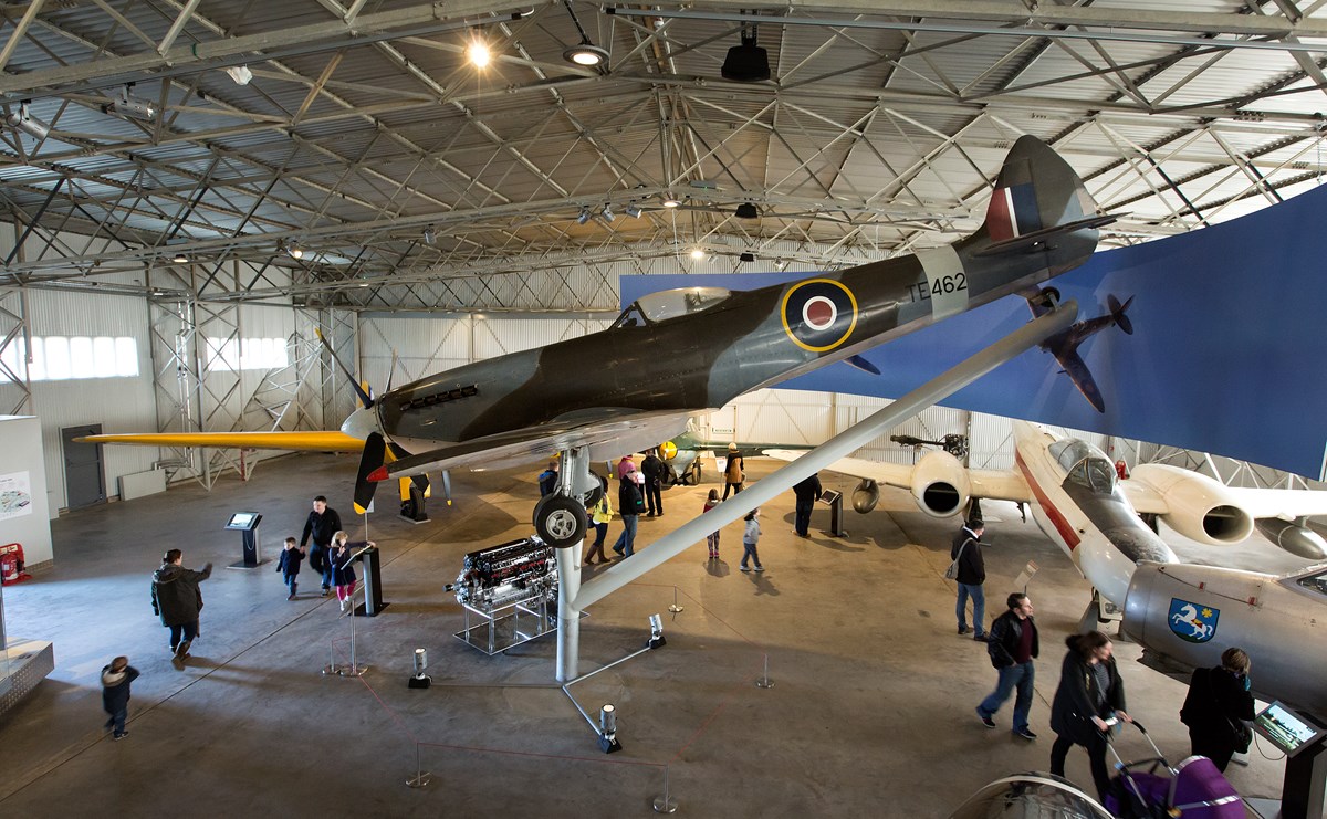 People walking around different aircraft in one of the hangars at the National Museum of Flight