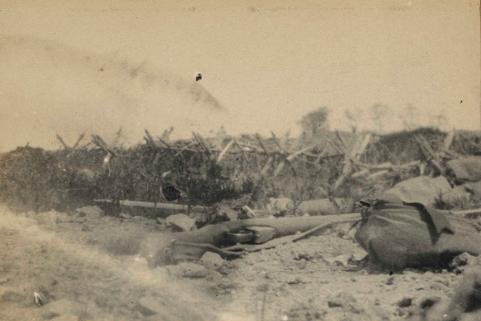 View taken from a dangerous position outside a front-line trench by Lieutenant LA Lynden-Bell, 1st Battalion Seaforth Highlanders, 1915. He took the photograph lying down. His rifle can be seen in the foreground.