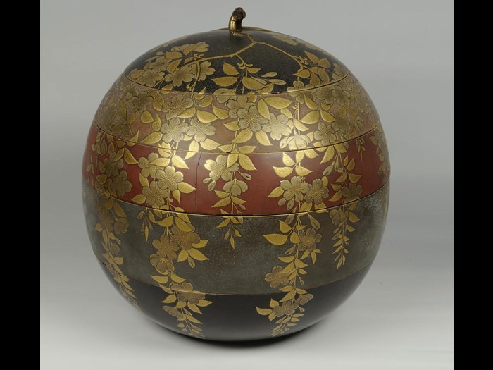 Spherical box of lacquered wood for cakes or sweets (kashi-bako), with four tiers in different coloured lacquer and a lid, decorated in raised gold lacquer with cherry blossom: Japan, c1800.