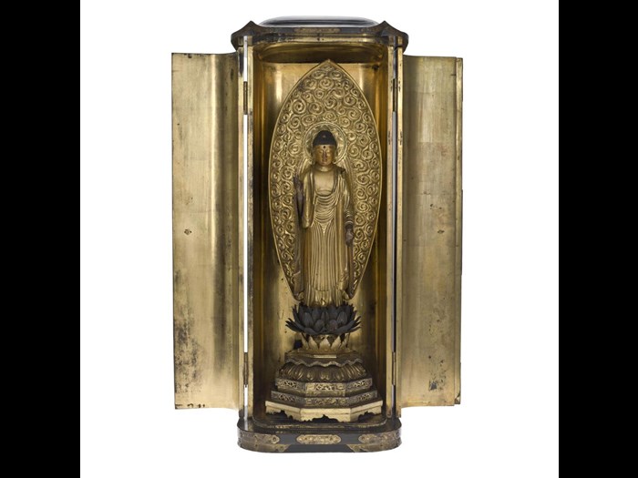 Shrine (zushi) of black lacquered wood with engraved metal mounts, containing figure of Amida Buddha, of carved, painted and gilt wood, standing on a lotus pedestal: Japan, late 17th - early 18th century.