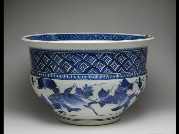 Large fish-bowl of porcelain with underglaze blue decoration of birds on branches and a diamond lozenge pattern above, with gold lacquer repairs to rim: Japan, 1660-80.