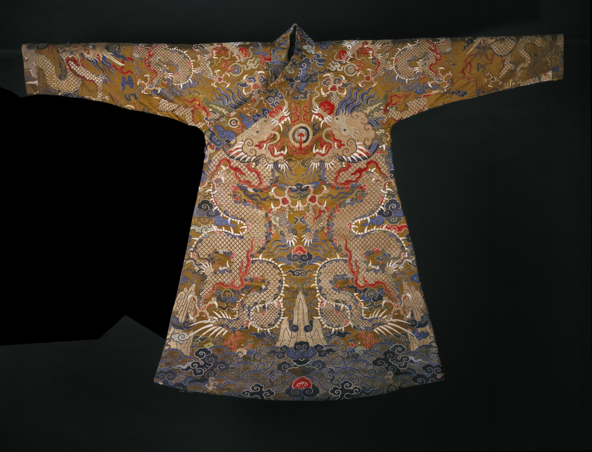 Man's brown silk chaofu or offical court robe, with a design of an elaborate cosmic scheme of dragons among clouds and waves, adapted for Tibetan use: China, early Qing period, c1675-1700.