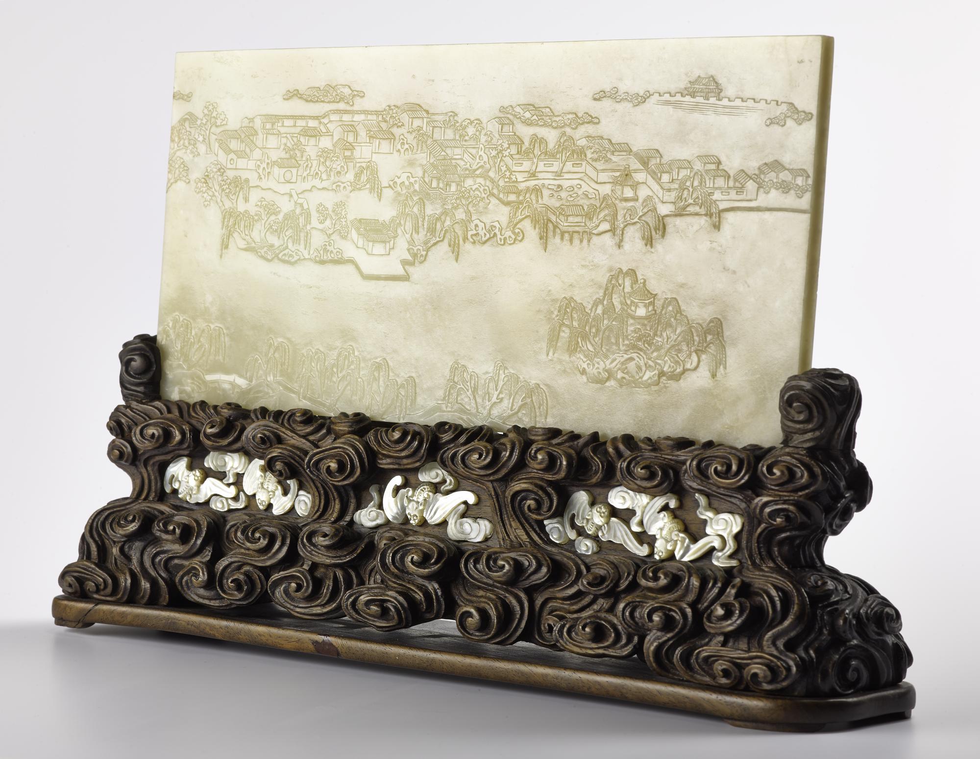 Table screen of pale grey jade, engraved on one side with a landscape and with a poem in the other side by the Qianlong Emperor, dated 1784, with carved wood stand inlaid with bats in mother-of-pearl: China, Qing Dynasty, Qianlong reign, 1735-1796.