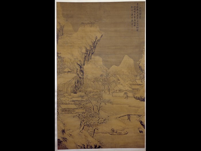 Hanging scroll painting, entitled Piles of Snow Sheltered by the Mountain, depicting buildings around a river with a fisherman poling a boat, beneath snow-covered mountains, in ink and colours on silk: China, Ming Dynasty, by Fan Jingwen, 1640.