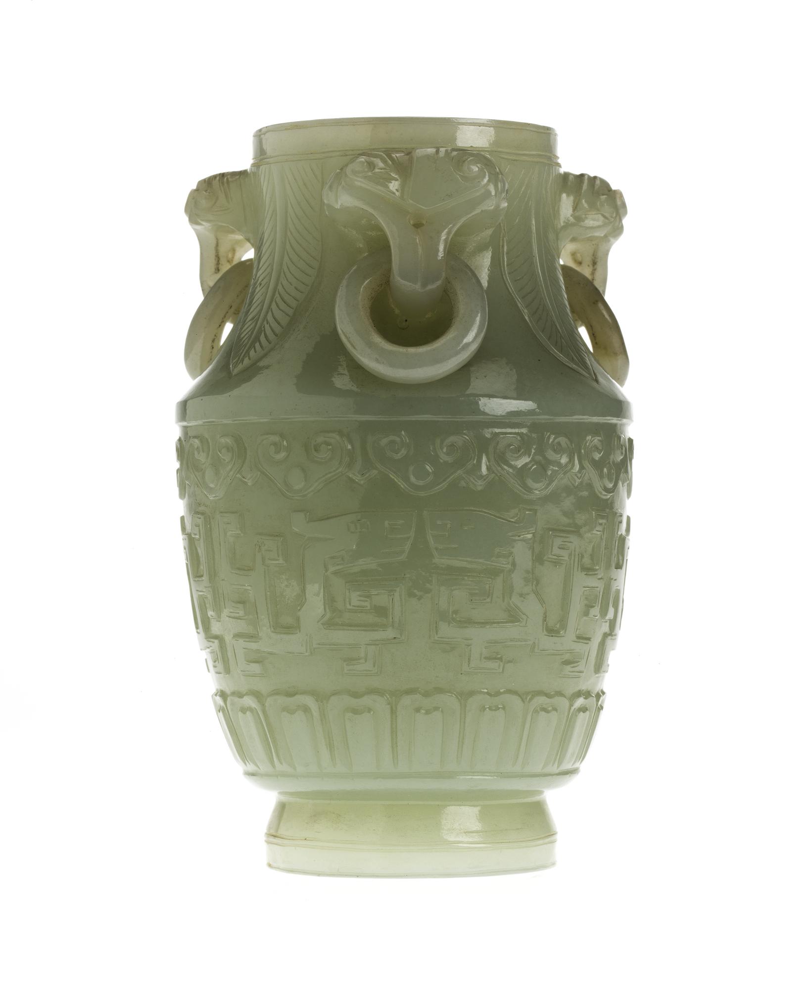 Vase of mutton-fat jade with three loose ring handles, carved with symmetrical designs of archaic dragons: China, 18th century.