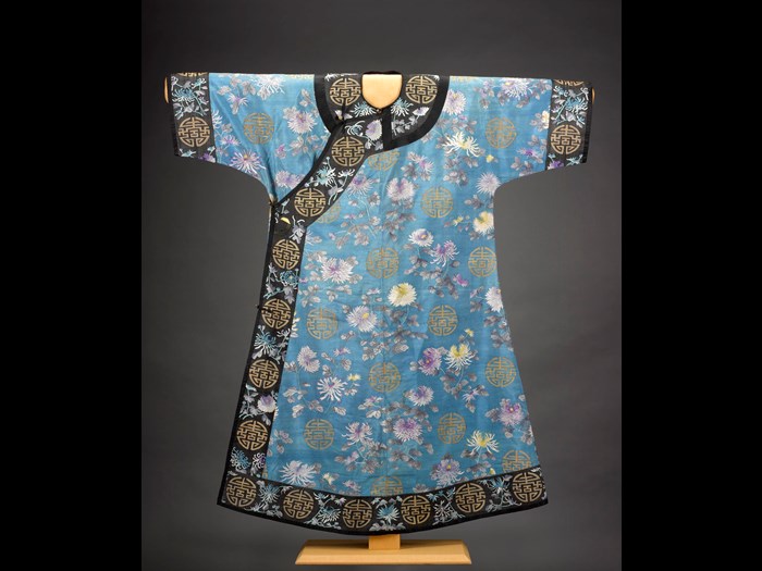 Woman's robe of blue silk in tapestry weave (kesi), with design of chrysanthemums and shou (longevity) characters, lined with yellow silk, in the style favoured by Empress Dowager Cixi, probably autumnal wear for older women: China, Qing Dynasty, late 19th century.