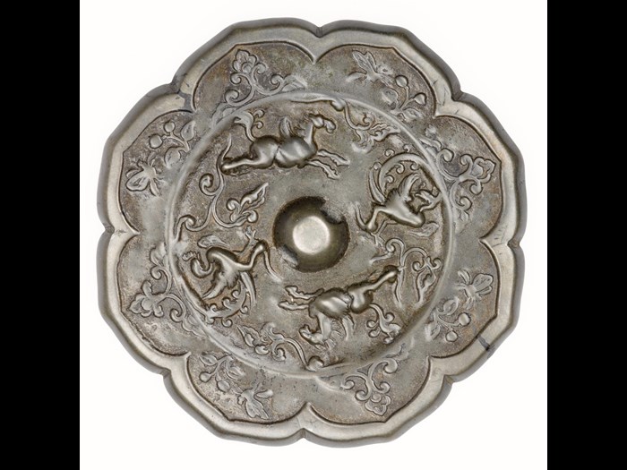 Bronze mirror, ogival with a central boss pierced for a cord, decorated with running winged horses and phoenixes, and a flower and butterfly border: China, Tang dynasty, 618 - 907 AD.