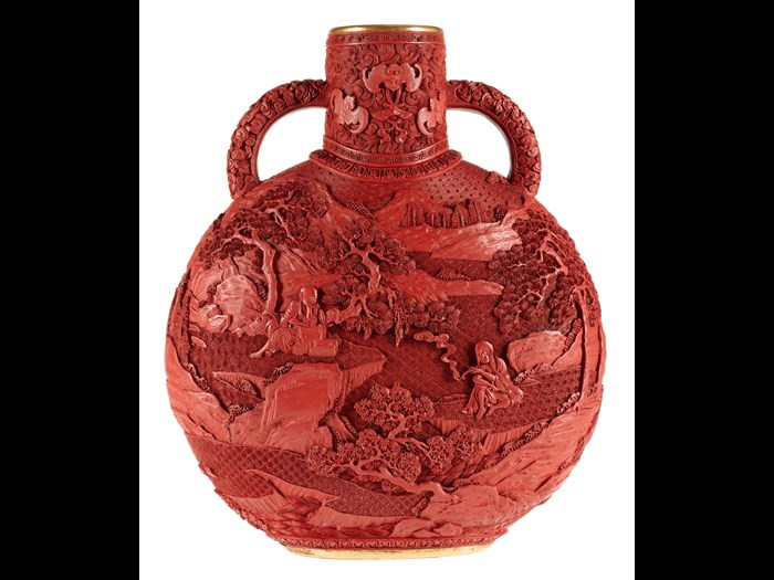 Moon flask of carved red lacquer on a porcelain body, decorated on both sides with a landscape: China, Qing dynasty, late 19th century.