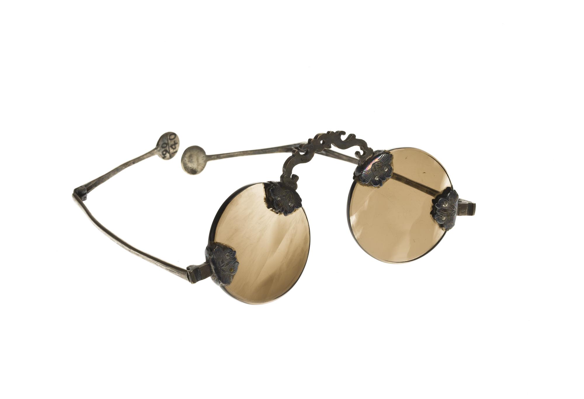 Pair of spectacles of smoky quartz, with engraved silver mounts and folding jointed legs: China, late 19th century.