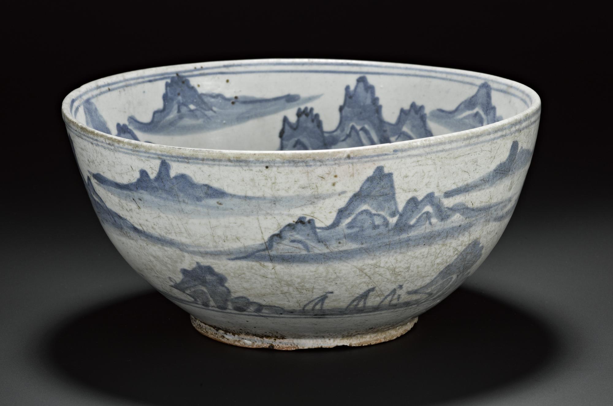 Porcellanous stoneware bowl with a red coloured body, and a green-white glaze, with uniform pale blue decoration, with mountain scenery and flying crane in central roundel: Korea, 19th century.