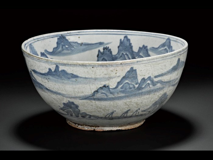 Porcellanous stoneware bowl with a red coloured body, and a green-white glaze, with uniform pale blue decoration, with mountain scenery and flying crane in central roundel: Korea, 19th century.