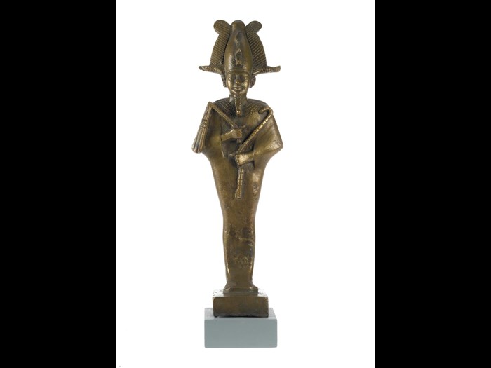 Statuette in bronze of Osiris, standing mummiform with Atef-crown and sceptres, and with seperate wooden base: Ancient Egyptian, from Saqqara, Lower Egypt, Late Dynastic Period, 664-332 BC.