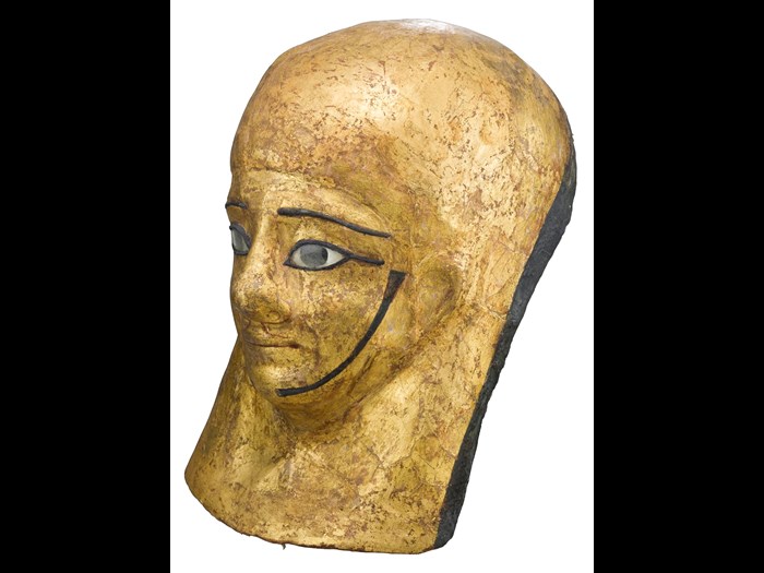 Mummy-mask of gilded and painted linen and plaster cartonnage, depicting Montsuef wearing a lappet-wig: Ancient Egyptian, excavated by A.H. Rhind in the tomb of Montsuef at Sheikh Abd el-Qurna, Thebes, Early Roman Period, c.9BC.