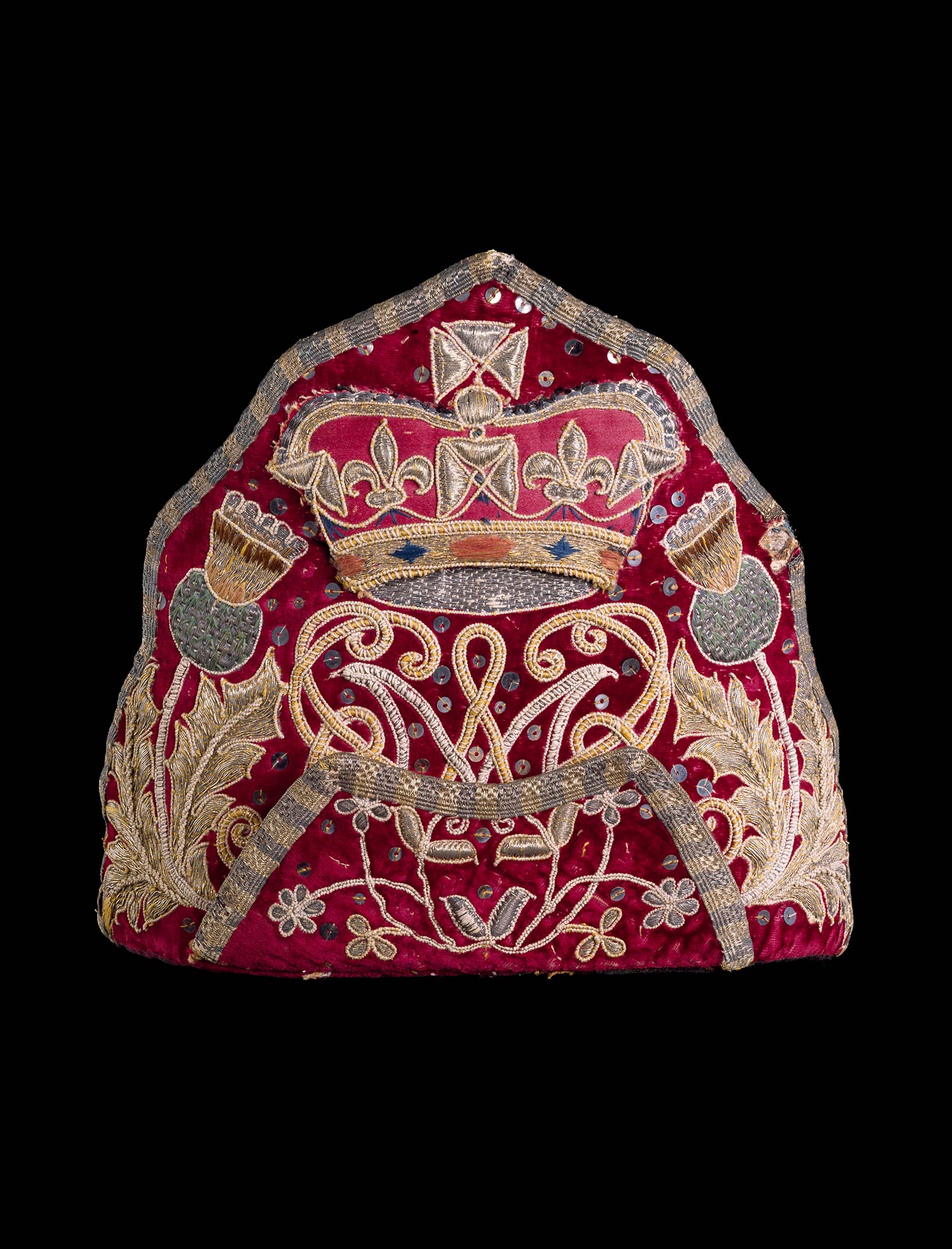 Embroidered mitre cap bearing the cypher of William and Mary flanked by thistles c.1690.