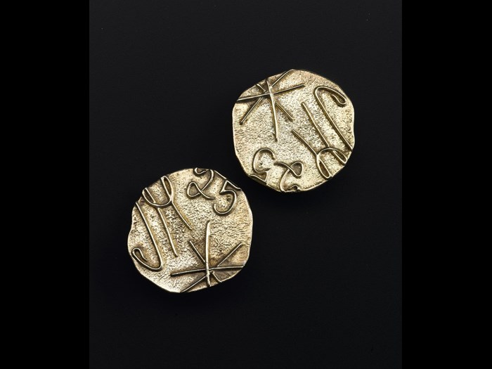 Clip on earrings of gold plated silver, depicting JM signature logo and the number 25, made to commemorate the company's 25th anniversary: British, designed for Jean Muir Ltd by Iain Young, 1991.
