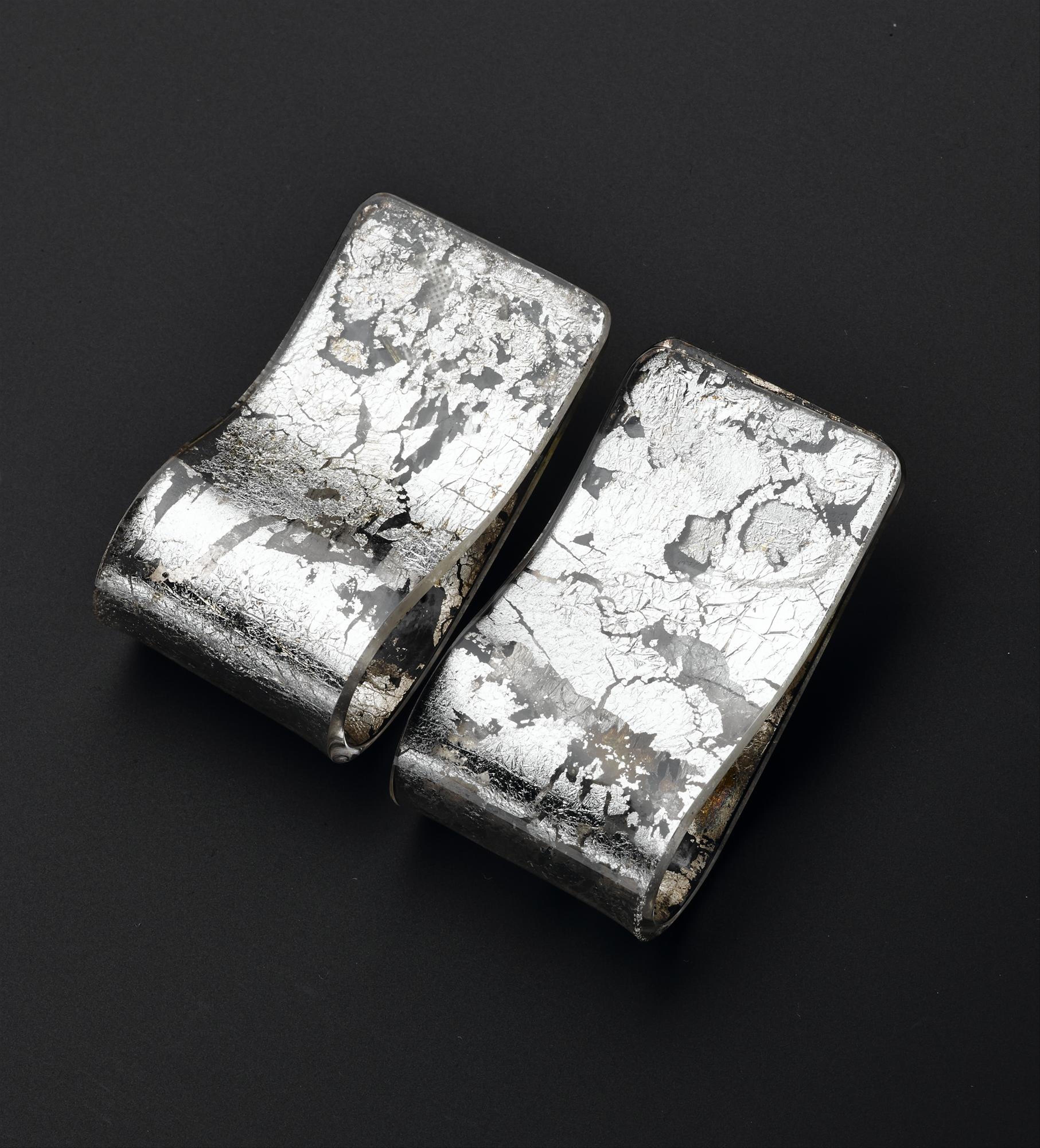Clip-on earrings of transparent acrylic decorated with silver leaf: British, designed and made for Jean Muir Ltd by C & N Buttons & Jewellery Production, 1980s.